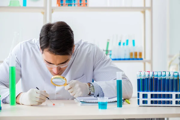 Giovane studente di chimica che lavora in laboratorio sui prodotti chimici — Foto Stock