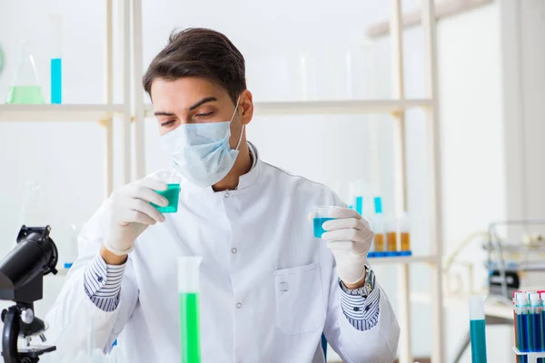 Giovane studente di chimica che lavora in laboratorio sui prodotti chimici — Foto Stock