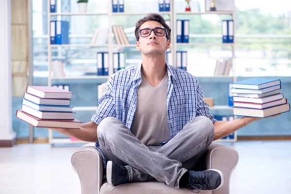 Estudiante leyendo libros y preparándose para los exámenes en la biblioteca —  Fotos de Stock