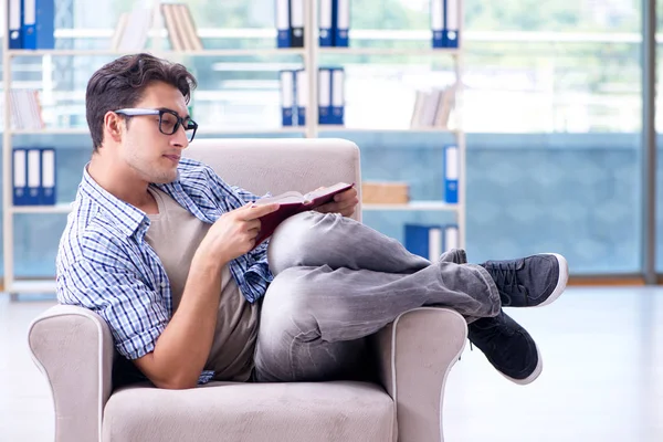 Estudiante leyendo libros y preparándose para los exámenes en la biblioteca —  Fotos de Stock