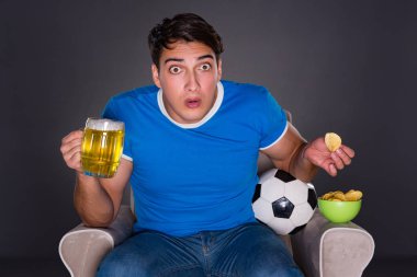 Gri arka planda spor izleyen adam