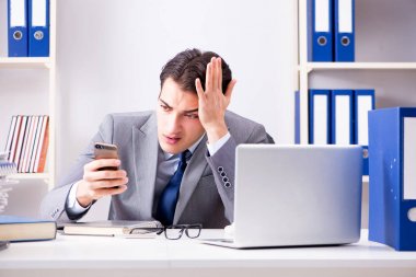 İşadamı ofis telefonundan konuşuyor.