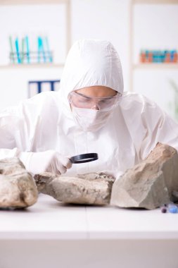 Bilimadamları laboratuarda taş örnekleri arıyor.