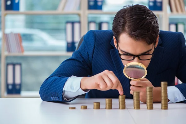 Uomo d'affari con pile di monete in ufficio — Foto Stock