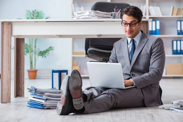 Geschäftsmann arbeitet und sitzt auf dem Fußboden im Büro — Stockfoto