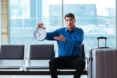 Havaalanı dinlenme odasında yolcu bekleyen adam.