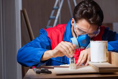 Genç adam ahşap parçaları DIY konseptinde yapıştırıyor.