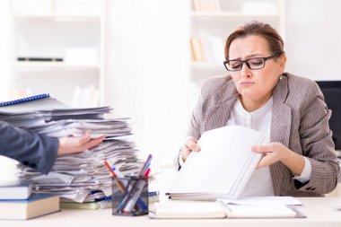 İşkadını devam eden evrak işleriyle çok meşgul.