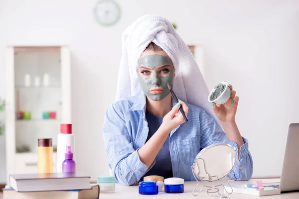 Frau trägt Tonmaske zu Hause mit Pinsel auf — Stockfoto