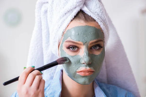 Mujer aplicando mascarilla de barro con cepillo en casa — Foto de Stock