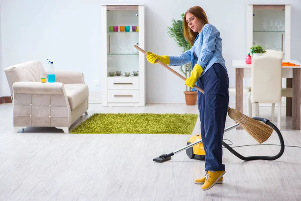 Giovane donna pulizia pavimento a casa facendo faccende domestiche — Foto Stock