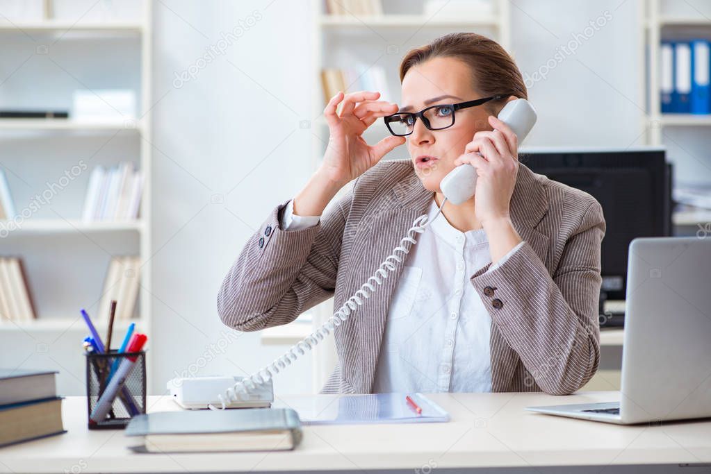 Businesswoman employee talking on the office phone