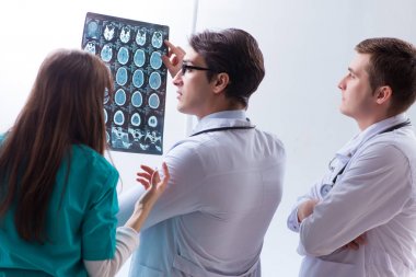 Üç doktor röntgen sonuçlarını tartışıyor