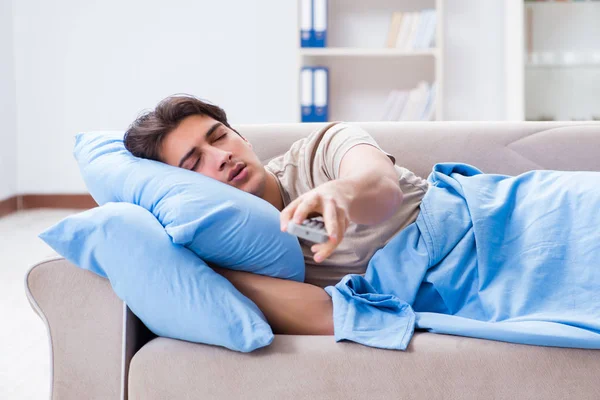 Uomo guardando la tv dal letto tenendo unità di controllo remoto — Foto Stock