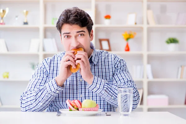 Человек, имеющий дилемму между здоровой пищей и хлебом в мошенничестве — стоковое фото
