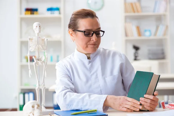 Ärztin untersucht menschliches Skelett — Stockfoto