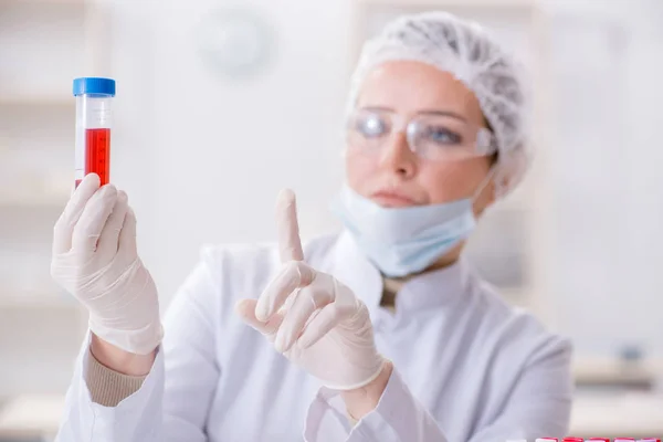 Mulher médico verificando amostras de sangue no laboratório — Fotografia de Stock