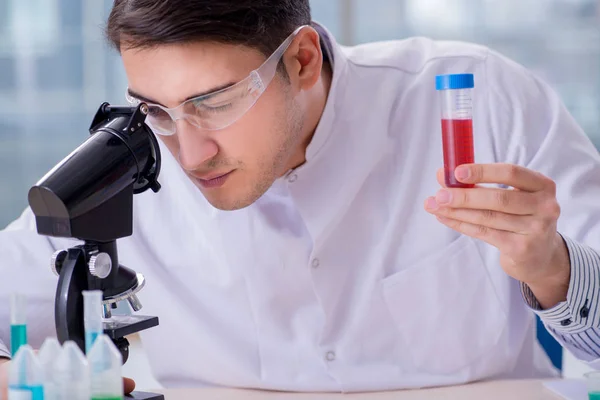 Homem médico verificando amostras de sangue no laboratório — Fotografia de Stock