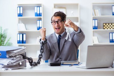 Ofis masasına zincirlenmiş meşgul bir çalışan.