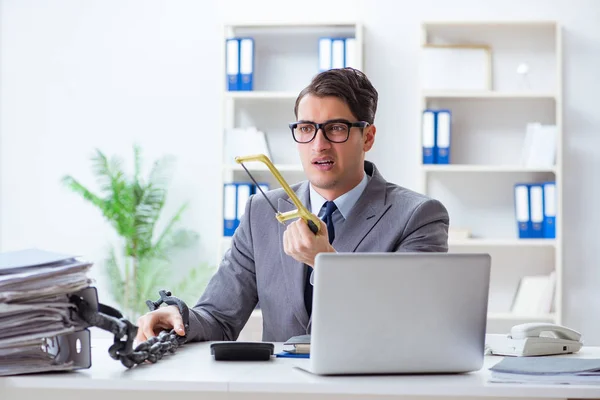 Upptagen anställd fastkedjad vid sitt skrivbord — Stockfoto