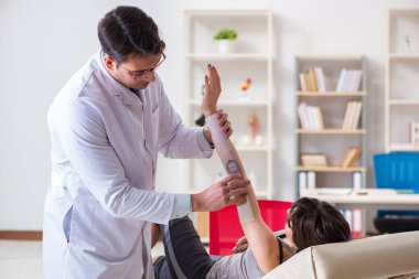 Doktor hastaların eklem esnekliğini kontrol ediyor