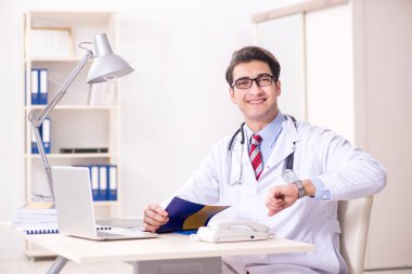 Hastane odasında çalışan yakışıklı genç bir doktor.