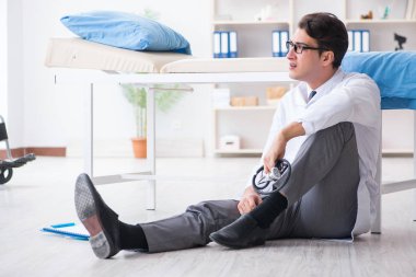 Doktor hastanede yerde oturuyor.