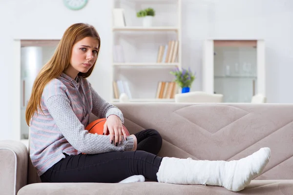 Junge Frau mit gebrochenem Bein zu Hause — Stockfoto