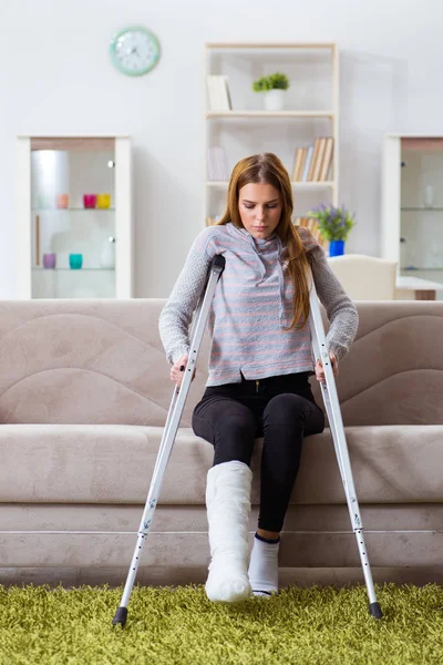 Mujer joven con la pierna rota en casa — Foto de Stock