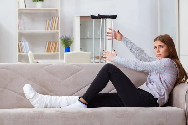 Mujer joven con la pierna rota en casa — Foto de Stock