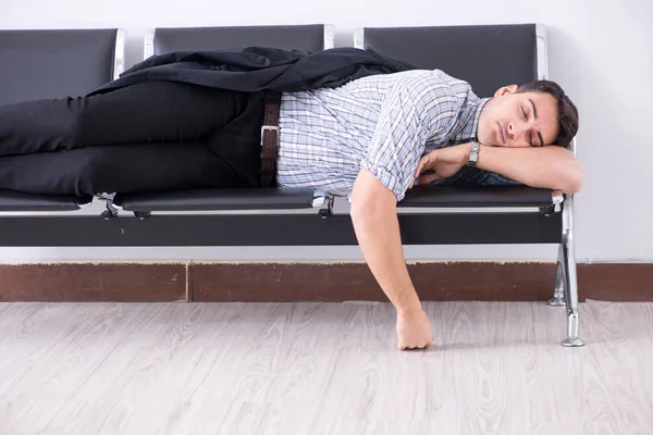 Mann schläft auf Stühlen im Flughafen — Stockfoto