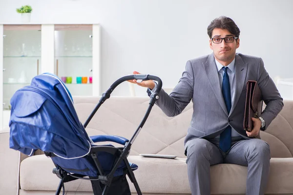 Businessman looking after newborn baby at home and teleworking — Stock Photo, Image