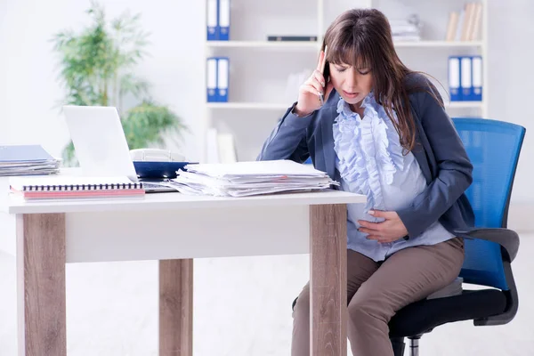 Zwangere vrouw worstelt om werk te doen in het kantoor — Stockfoto