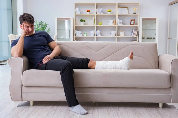 Muž se zlomenou nohou se zotavuje doma — Stock fotografie
