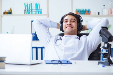 Hastanede öğle arasında müzik dinleyen mutlu doktor.