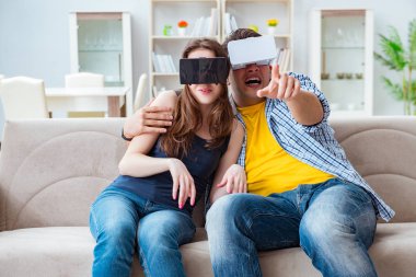 Genç bir aile sanal gerçeklik gözlükleriyle oyun oynuyor.