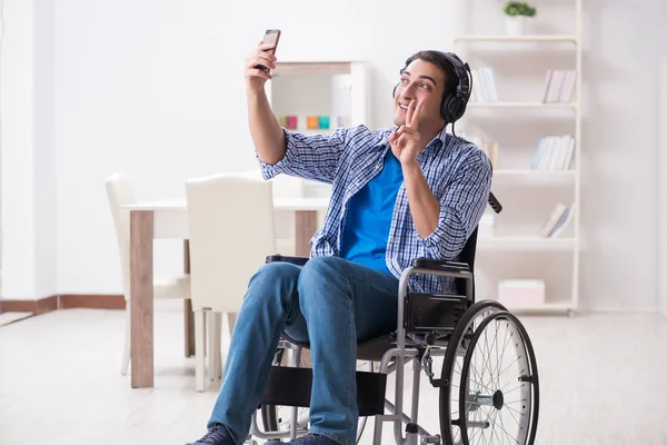 Hombre discapacitado escuchando música en silla de ruedas —  Fotos de Stock