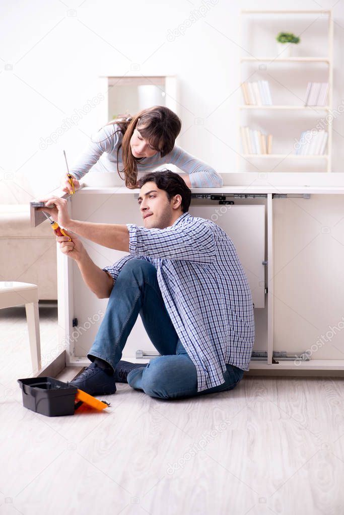 Husband repairing broken table at home
