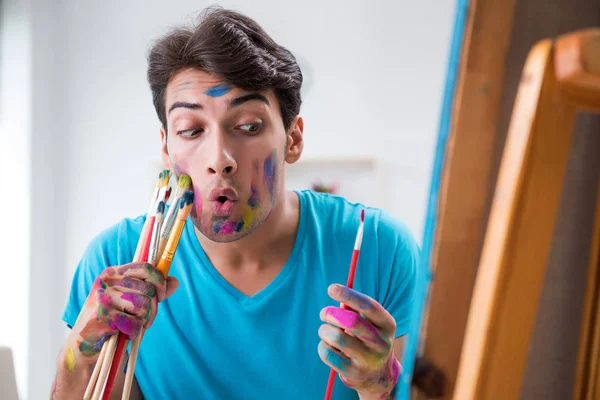 Jonge grappige kunstenaar werkt aan nieuw schilderij in zijn atelier — Stockfoto