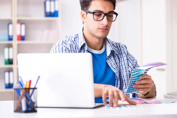 Joven diseñador trabajando en un nuevo proyecto y eligiendo colores —  Fotos de Stock