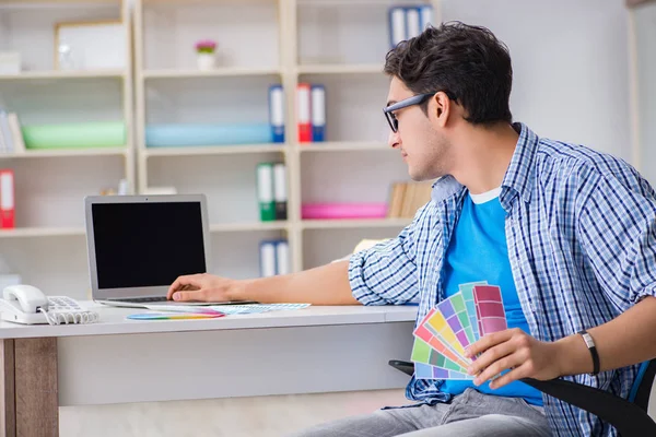 Joven diseñador trabajando en un nuevo proyecto y eligiendo colores — Foto de Stock