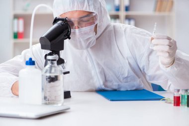 Laboratuvarda kimyasallar üzerinde çalışan genç bir kimyager.