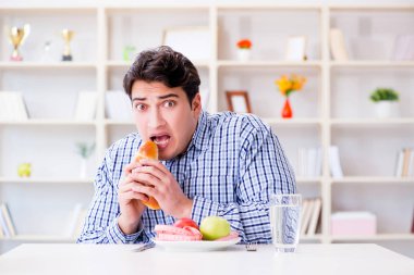 Man having dilemma between healthy food and bread in dieting con clipart