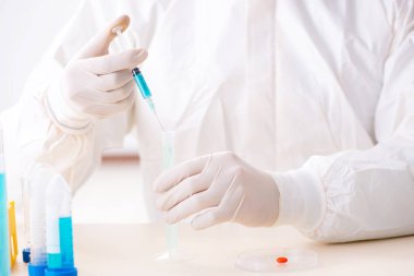 Laboratuvarda kimyasallar üzerinde çalışan genç bir kimyager.