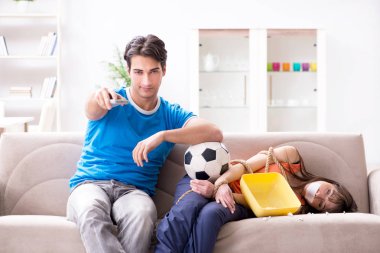 Adam spor maçı izlemek için karısını bağlıyor.