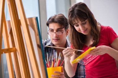 Stüdyoda resim sınıfında sanatçı koçluğu yapan bir öğrenci.
