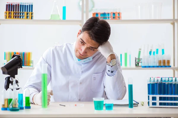 Jovem estudante de química que trabalha em laboratório em produtos químicos — Fotografia de Stock