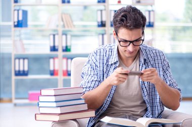 Öğrenci kitap okuyor ve kütüphanede sınavlara hazırlanıyor