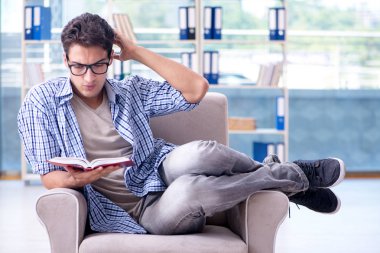 Öğrenci kitap okuyor ve kütüphanede sınavlara hazırlanıyor