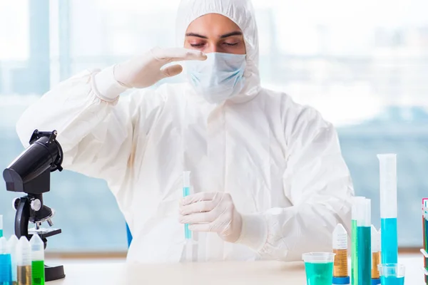 Jovem estudante de química que trabalha em laboratório em produtos químicos — Fotografia de Stock